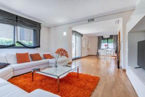 a living room with a white couch and a table at Charming Home with Pool and Garden, Just Outside Madrid in Villanueva de la Cañada