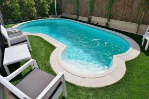 a small swimming pool with a chair and a table at Charming Home with Pool and Garden, Just Outside Madrid in Villanueva de la Cañada