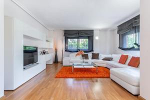 a living room with a white couch and a orange rug at Charming Home with Pool and Garden, Just Outside Madrid in Villanueva de la Cañada +43 photos