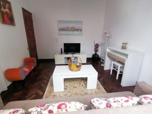 Una sala de estar con una mesa de café blanca y un piano. en Westerland House, en Ribeira Brava