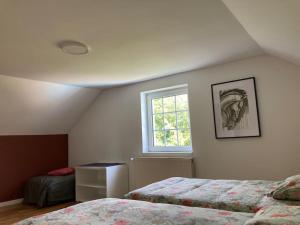 a bedroom with two beds and a window at Maison avec piscine privée au calme in Schlierbach +26 photos