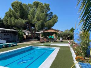 a swimming pool in a yard with a tree at Casa de campo en pelayos in Pelayos de la Presa