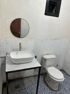 a bathroom with a sink and a toilet and a mirror at HaCaSeMa Transient House in Acala