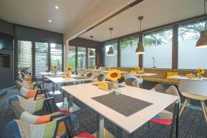 a restaurant with tables and chairs and windows at Edi Hotel in Sofia