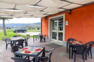 an outdoor patio with tables and chairs and a car at Locanda dei 4 in Narni