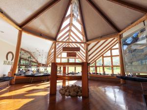 a large room with a wooden ceiling with windows at Hotel Las Torres Patagonia in Torres del Paine
