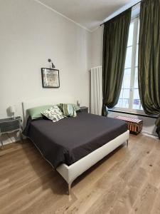 a bedroom with a bed and a large window at Rolli House in Genova