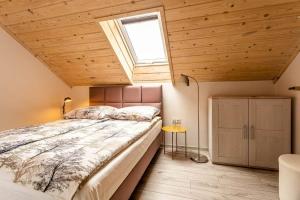 Un dormitorio con una cama grande con ventana. en Domki Adek 2, en Władysławowo
