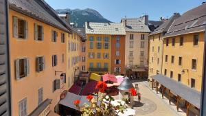 a city street with tables and umbrellas and buildings at Appartement de charme le 1707 au cœur de la cité Vauban in Briançon