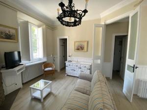 a living room with a couch and a chandelier at Principal Casa Pomar in Camprodon
