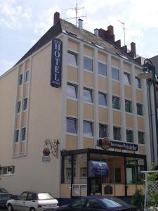 un grand bâtiment avec une voiture garée devant lui dans l'établissement Hotel Regina, à Darmstadt