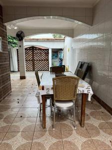 a kitchen with a table and chairs in a room at Casa espaçosa 6 min da praia in Bertioga