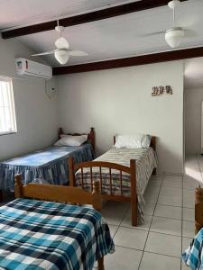 a room with two beds in a room at Casa espaçosa 6 min da praia in Bertioga