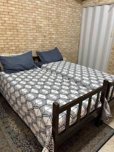 a bed with blue pillows on top of it at Casa espaçosa 6 min da praia in Bertioga +30 photos