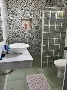 a bathroom with a sink and a toilet at Casa espaçosa 6 min da praia in Bertioga