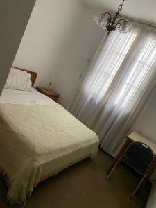 Un dormitorio con una cama y una ventana con una lámpara de araña. en Hotel guido palace, en Buenos Aires