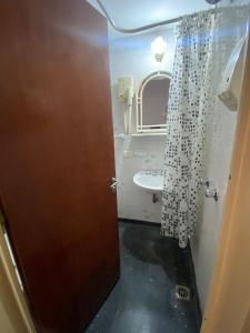 Un baño con lavabo, inodoro y puerta. en Hotel guido palace, en Buenos Aires