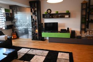 a living room with a tv and a green desk at Golden Valley in Sarajevo