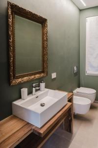 a bathroom with a sink and a toilet and a mirror at Senape - Menaggio by LoveComo in Menaggio +18 photos