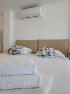 a bed with two pillows and a blanket on it at Andromeda Seaside Apartments in Vlikhón