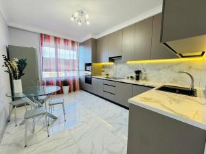 a kitchen with a glass table and a counter top at 1835 Rams City Mountain View Apartment in Almaty