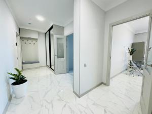 an empty hallway with white walls and a large mirror at 1835 Rams City Mountain View Apartment in Almaty