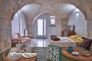 ein Schlafzimmer mit einem Bett, einer Couch und einem Tisch in der Unterkunft Mille908 in Muro Leccese