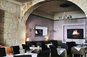 um restaurante com mesas e cadeiras e uma parede de pedra em Hôtel du Palais des Papes em Avignon