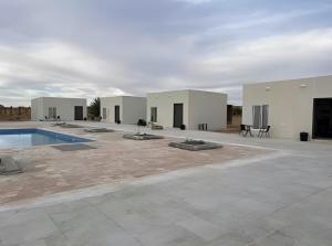 a building with a swimming pool in a courtyard at Studio overlooking pool amid flowering and quiet in Al-ʿUla