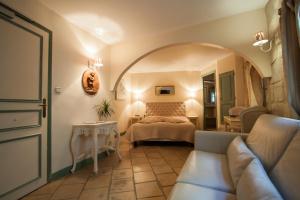 um quarto com uma cama e um sofá num quarto em Hôtel du Palais des Papes em Avignon