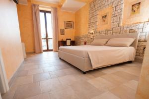 um quarto com uma cama e uma parede de pedra em Villa Tivoli em Guidonia