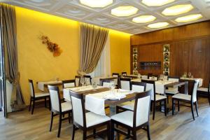 a dining room with tables and chairs and yellow walls at Villa Tivoli in Guidonia