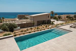 a swimming pool in front of a building at Akre Villas in Ierapetra