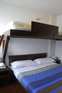 セストリエーレにあるNevesestriereのベッドルーム1室(木製ヘッドボード付きのベッド1台付)
