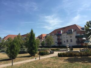 um grupo de edifícios num parque com árvores em Résidence Le Parc 68 em Colmar