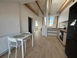 a kitchen with a table and chairs in a room at Apartament Franciszkańska 3 in Tarnów