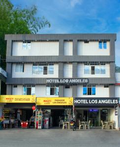 a building with tables and chairs in front of it at Hotel Los Angeles in Calarcá