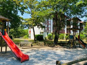 a playground with a red slide in front of a building at Appartement Biscarrosse lac-golf in Biscarrosse