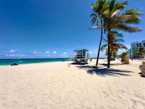 a beach with a palm tree and a lifeguard tower at Southwinds Inn by The Gold Nests in Hollywood +158 photos