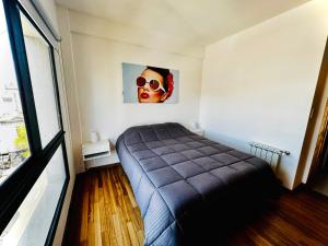 a bedroom with a bed and a picture of a mask at Center Suites, 3 ambientes con cochera opcional in La Plata