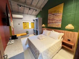 a bedroom with a bed and a green wall at Pousada Refúgio de Maresias in Maresias