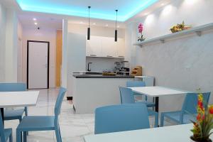 a kitchen and dining room with blue chairs and tables at B&B AIDA Rooms Cefalù in Cefalù