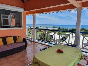 a living room with a table and a view of the ocean at La Villa Océane in Le Moule