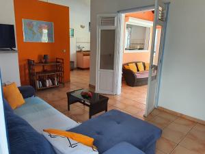 a living room with a blue couch and a table at La Villa Océane in Le Moule