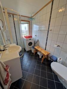 a bathroom with a sink and a toilet and a table at Feriehus ved fjorden i Solvorn in Luster