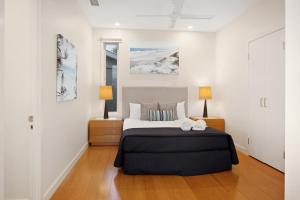 a bedroom with a large bed and two lamps at Rainbow Ocean Palms Resort in Rainbow Beach