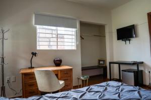 a bedroom with a bed and a desk and a window at Uotan in Mexico City