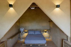 a bed in a attic with two lights and a fan at Bambú Corner - Casa Consciente in Brisas de Zicatela +38 photos