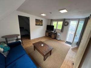 a living room with a blue couch and a table at Maple Tree Chambre d'hôtes in Darnac