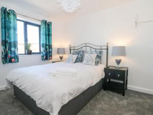 a bedroom with a large bed with blue curtains at Priestleys Retreat in Blackburn
